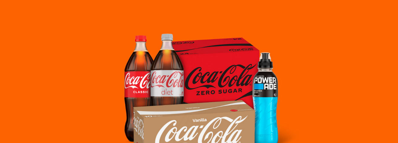 A selection of Coca-Cola products, including bottles of Coca-Cola Classic and Diet Coke, a case of Coca-Cola No Sugar, a case of Vanilla Coca-Cola, and a Powerade drink.