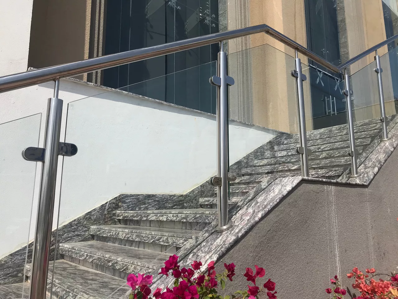 stainless steel Glass or glazed hand rail at entrance stair case steps with the planter box flowers which giving elegant look reception area of an  commercial building
