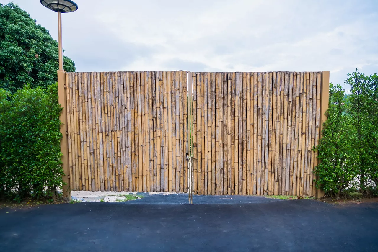 A sturdy bamboo gate flanked by lush greenery, showcasing a blend of natural materials and modern design. Ideal for eco-friendly and rustic-themed properties.