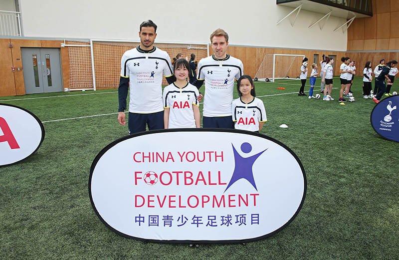 中國青少年足球發展計劃因在白鹿徑球場上的比賽而聲名大躁，在熱刺隊服中亮相。（從左至右）熱刺隊的球員Nacer Chadli 和 Christian Eriksen，以及來自中國青少年足球發展計劃，扮演球員吉祥物的兩名女孩。