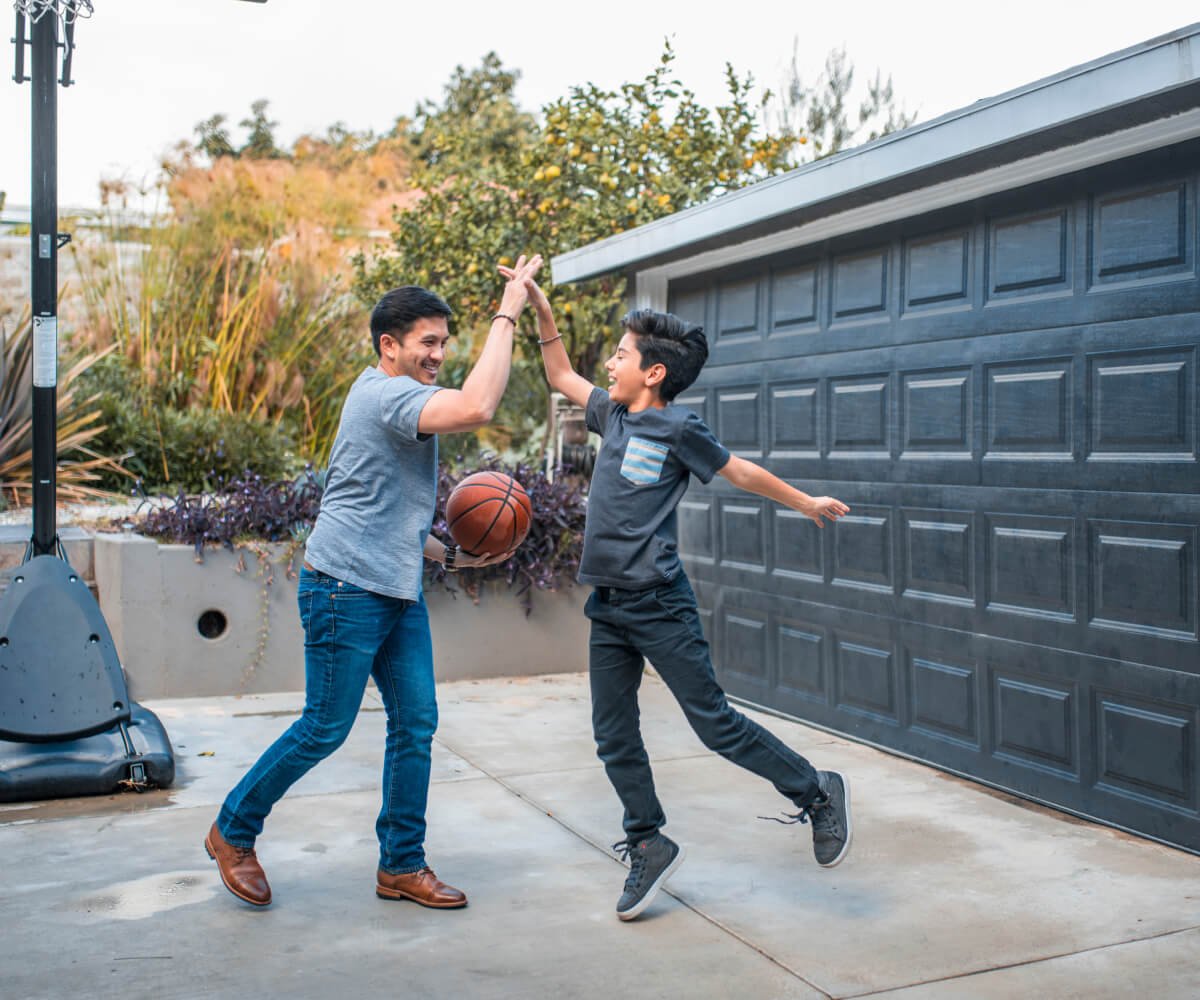 A man and a boy joyfully leap into the air, capturing a moment of shared excitement and happiness.