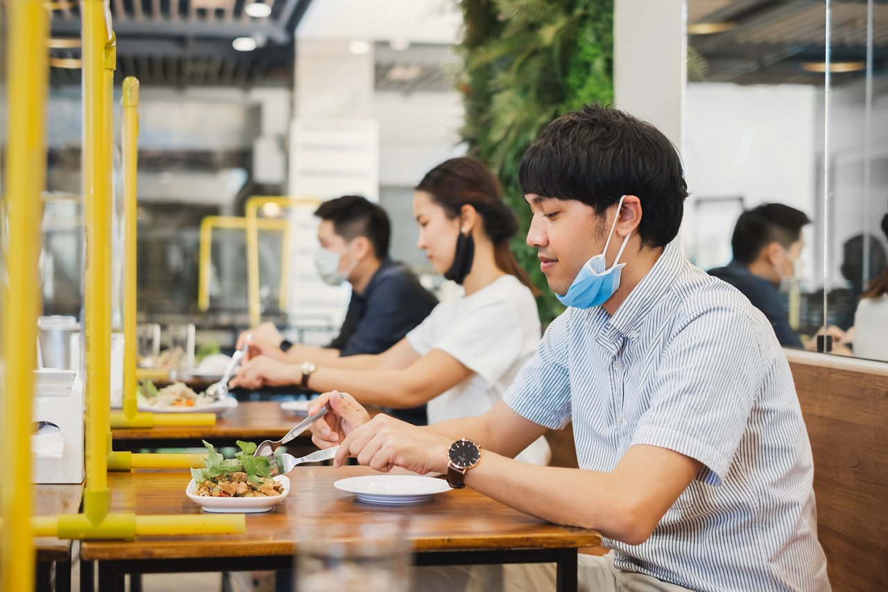 Asian man eats solo at his table at a restaurant