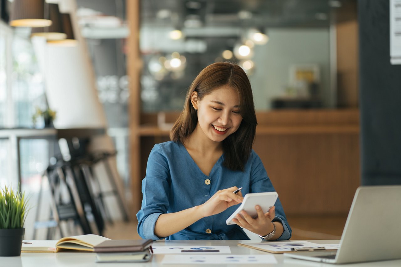 Young woman calculates her bills at a cafe