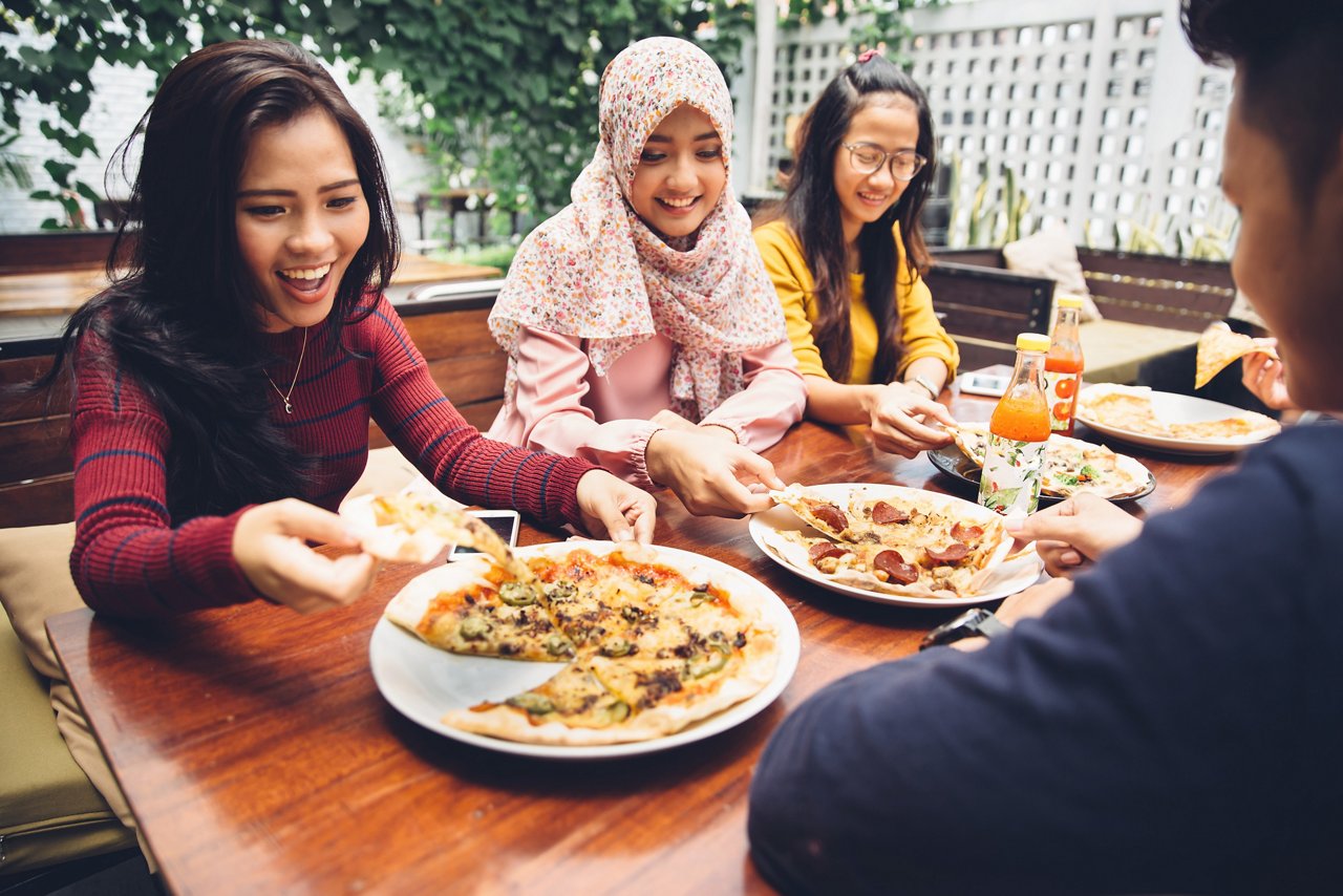 Group of friends enjoy pizza outdoors 