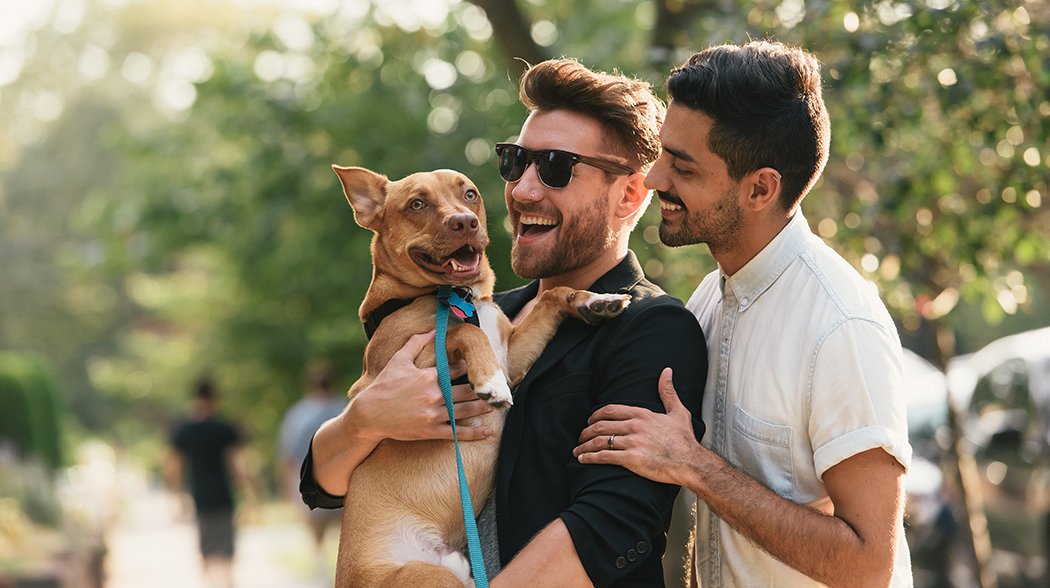 tow men holding dog