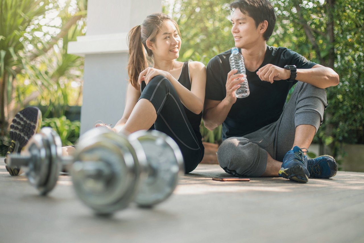 Couple sits on the floor to rest after a workout