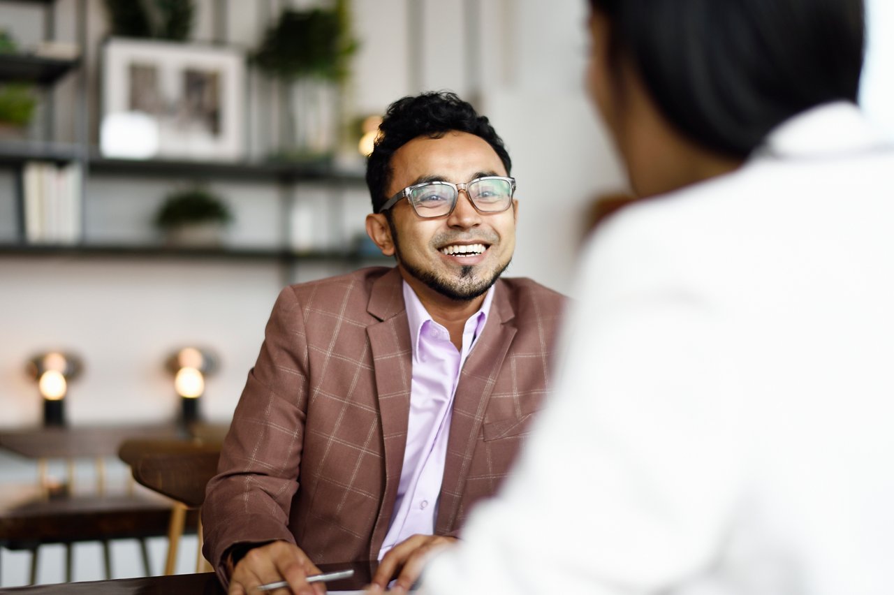 An Asian man discusses investment funds and insurance during a consultation meeting.