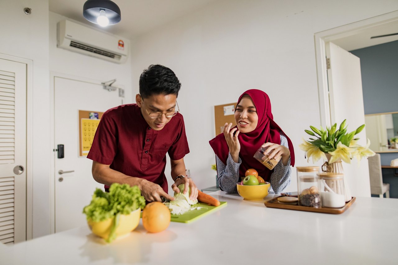 A young man and woman prepare a home-cooked meal in the kitchen