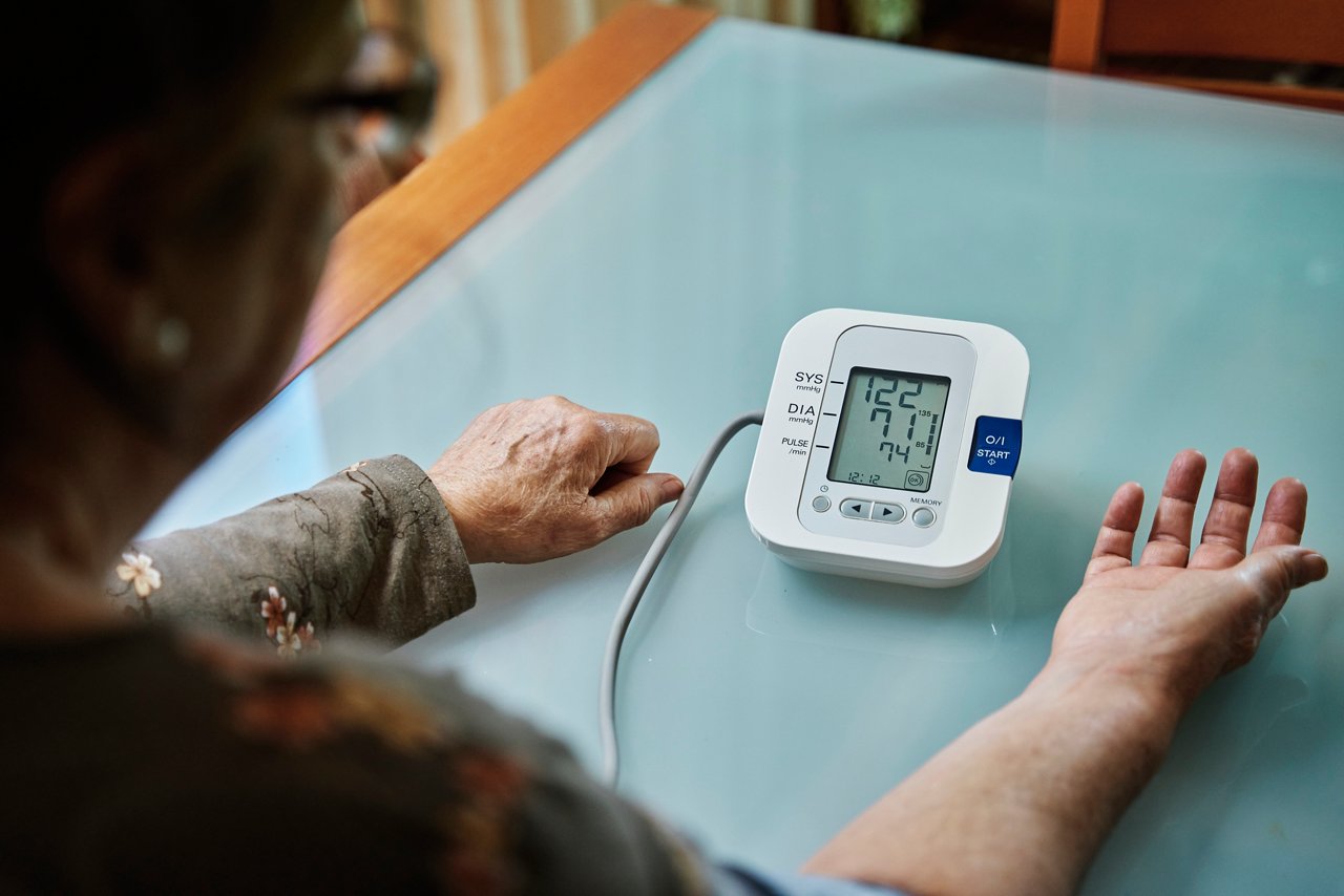 一名老年女性使用血壓計測量血壓