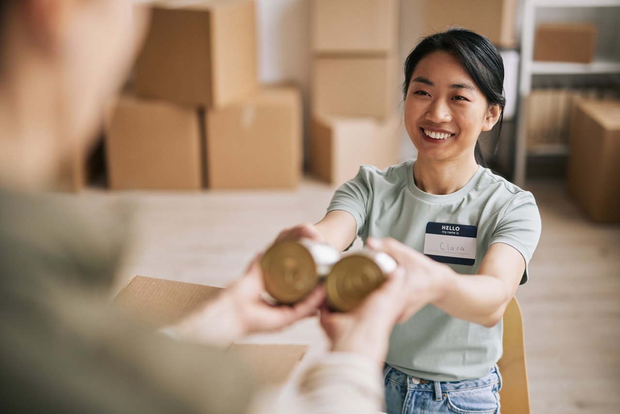 A young female volunteer giving canned goods