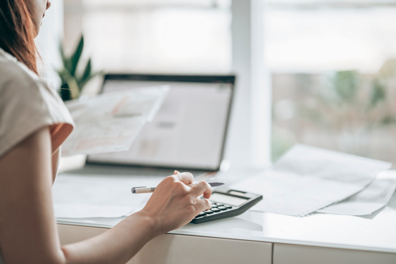 Woman uses calculator as she looks over documents