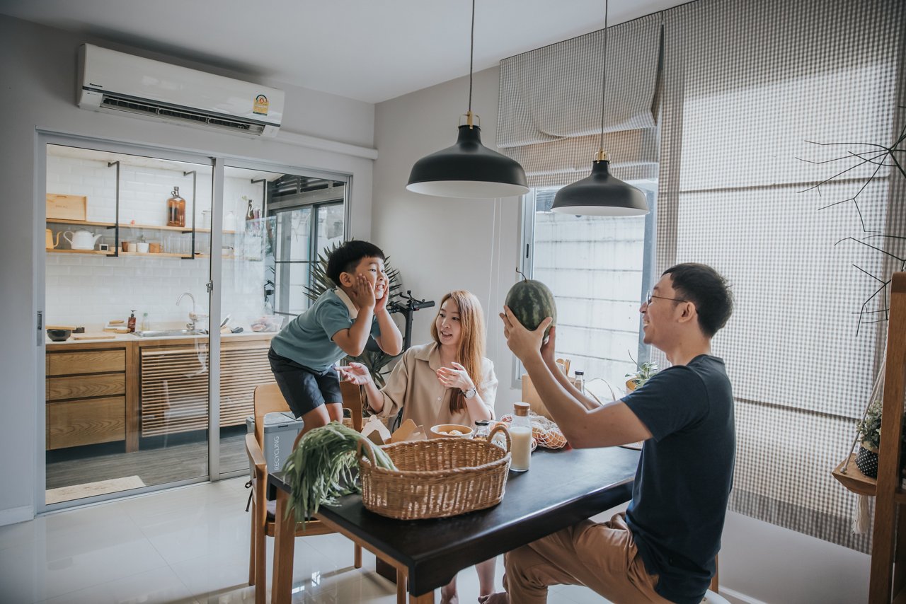 A group of elderlies making salad and fruit juices in a kitchen. 