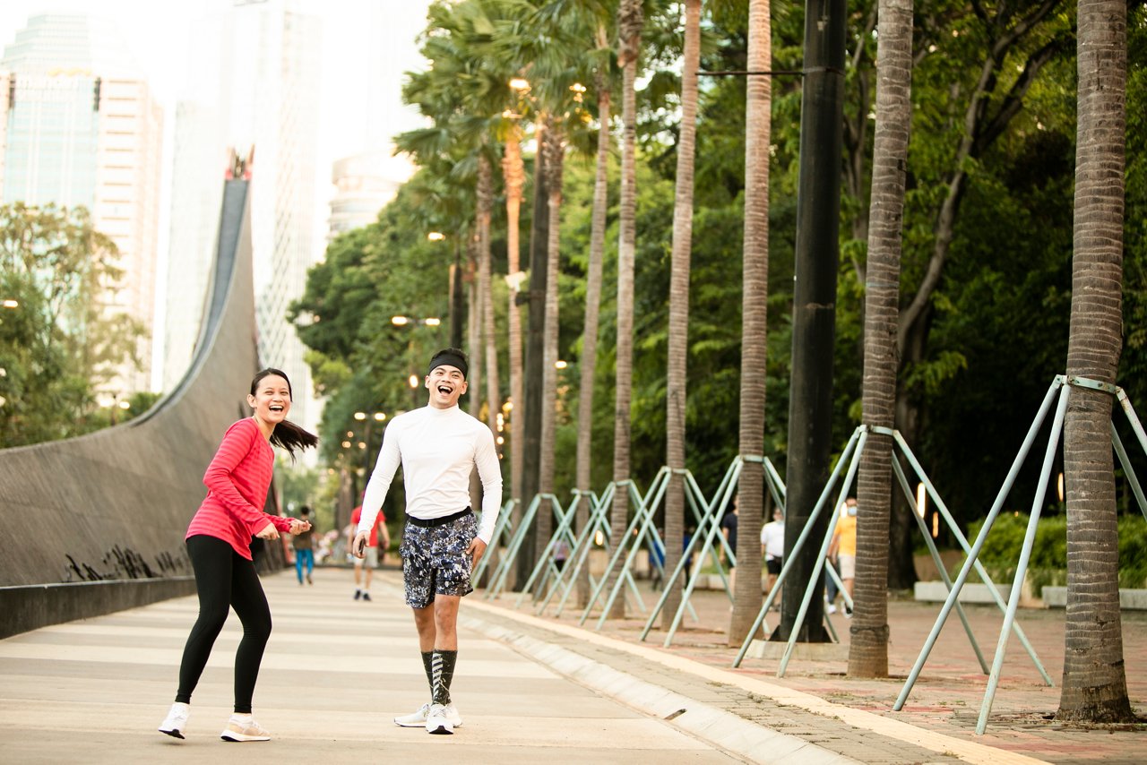 Asian man and woman exercising in a park