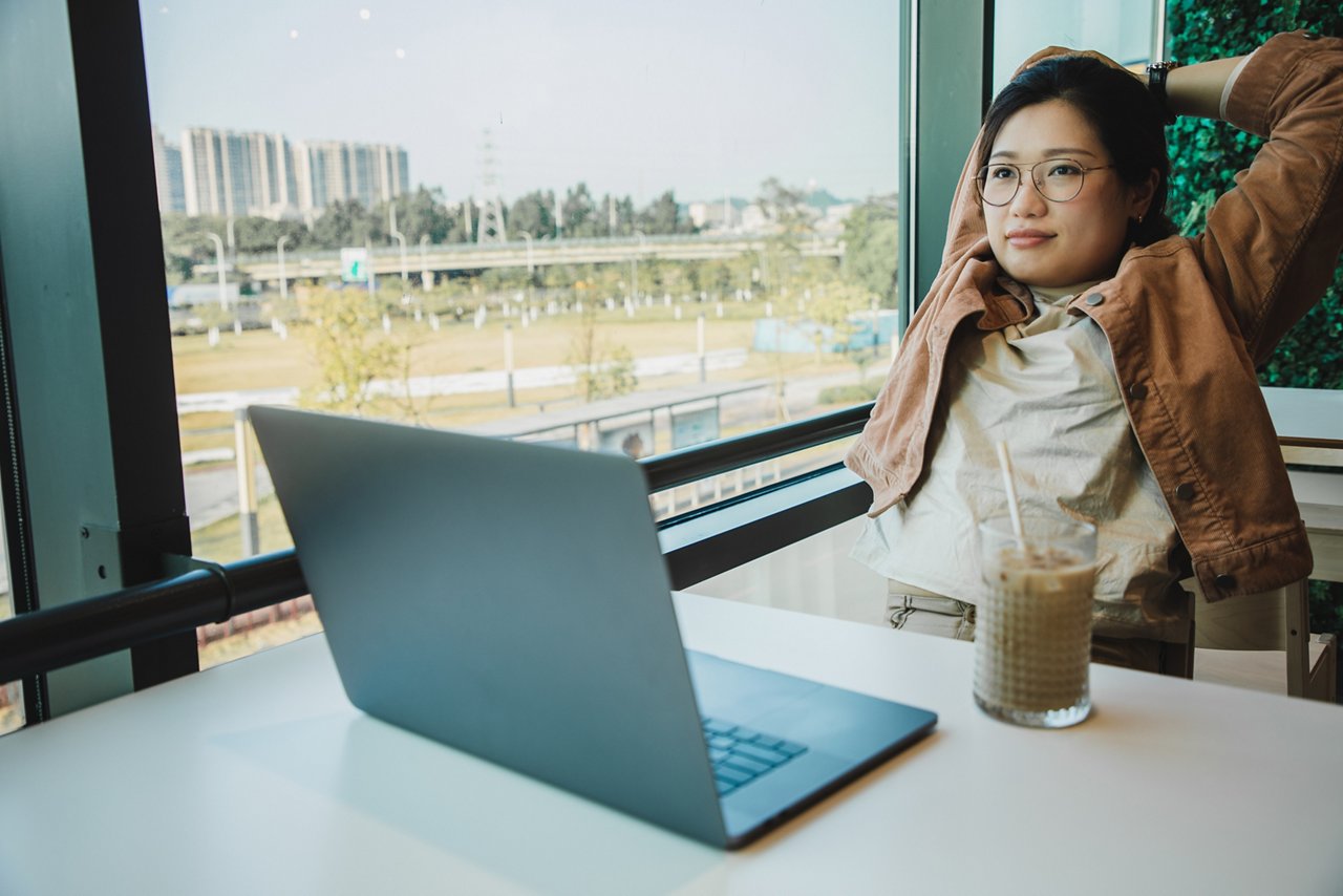 Woman stretching her arms in front of her laptop