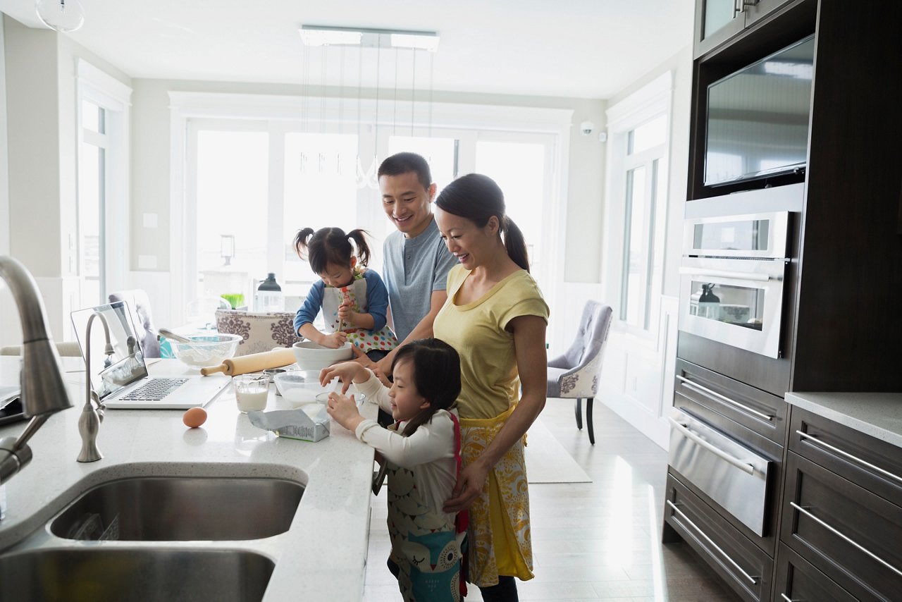 Asian family of four baking in the kitchen.
