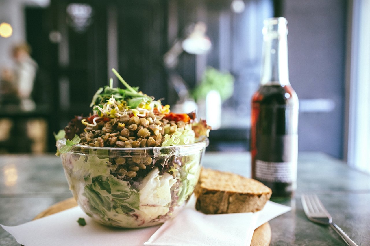  Close-up of salad bowl on the table with wine and bread in the background