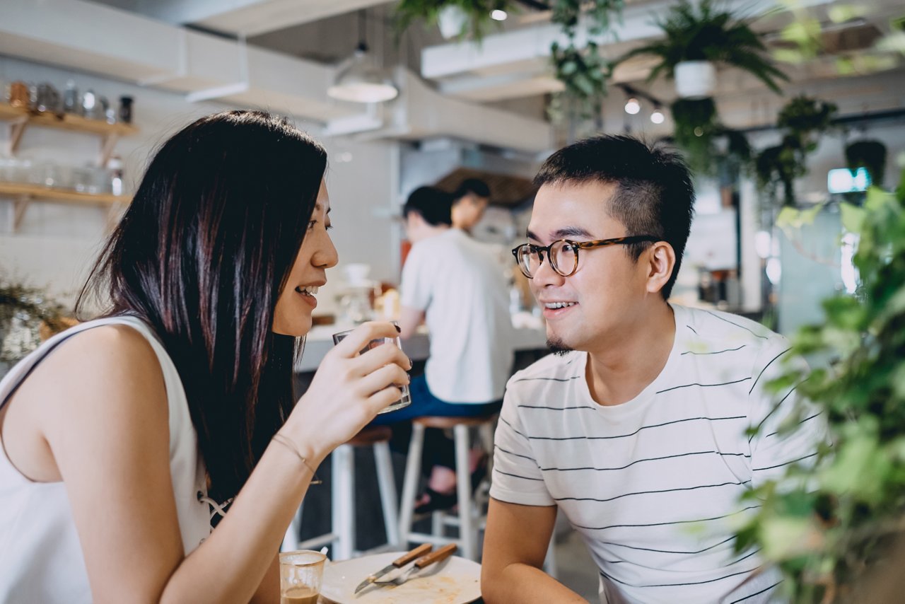 Couple talking and smiling after having a meal at a cafe
