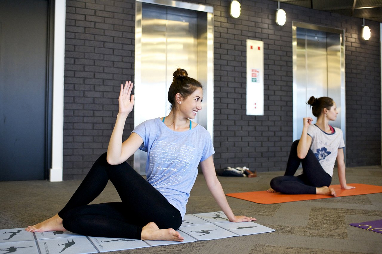 兩名健康亞洲女性身穿運動裝，正在瑜伽墊上練習 