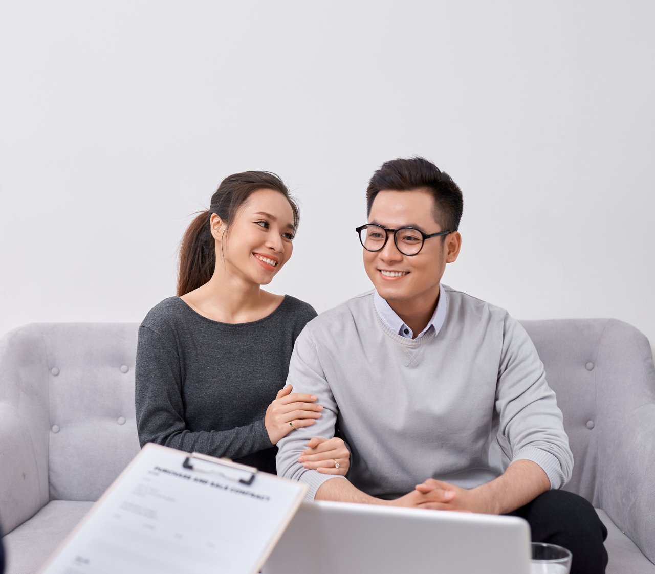 Happy young couple hold each otherÃ¢??s hands listening to female agent, planning wedding, consulting investment advisor, hearing good news, casual marriage registration, buying real estate