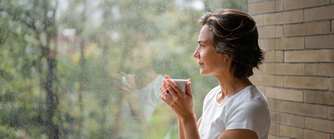 Picture of lady smiling drinking a coffee