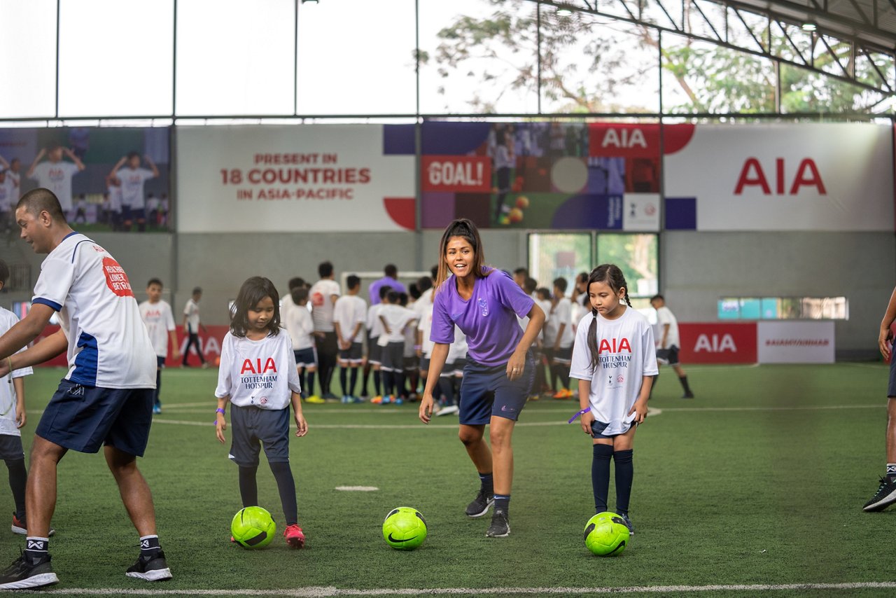 友邦保險在緬甸舉辦足球訓練營，托定咸熱刺國際青訓教練Shannon Maloney指導參與訓練的女孩。