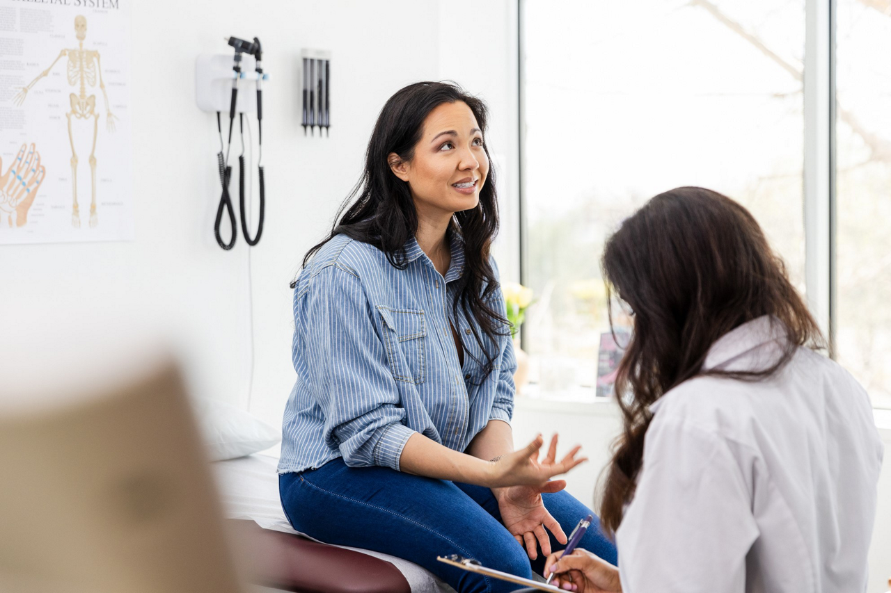 A female patient discussing her health with a female doctor in the clinic