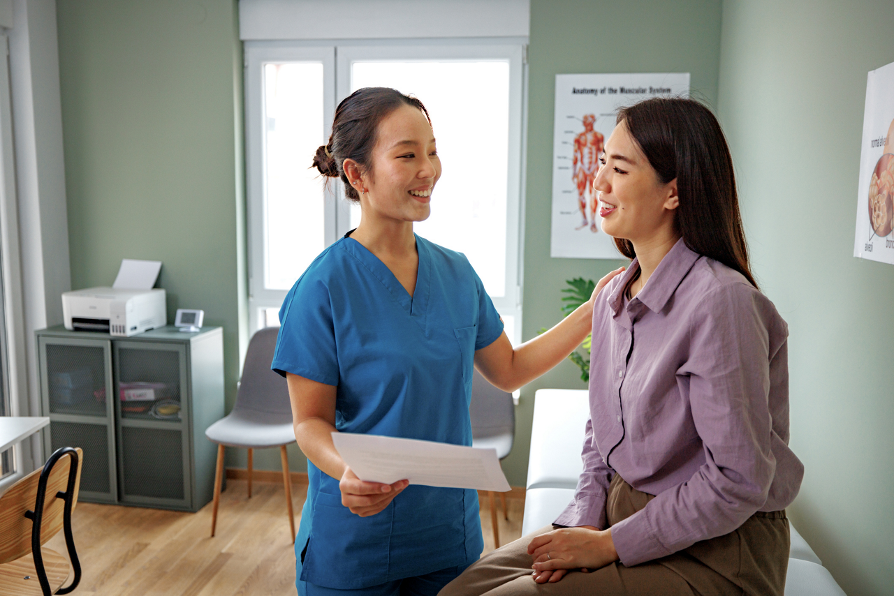 A female patient with a medical professional sharing a report in the clinic.