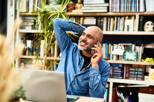 man sitting talking on phone and smiling