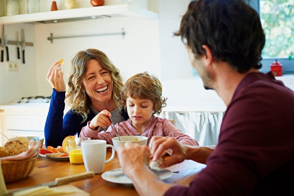 Family eating breakfast and smiling