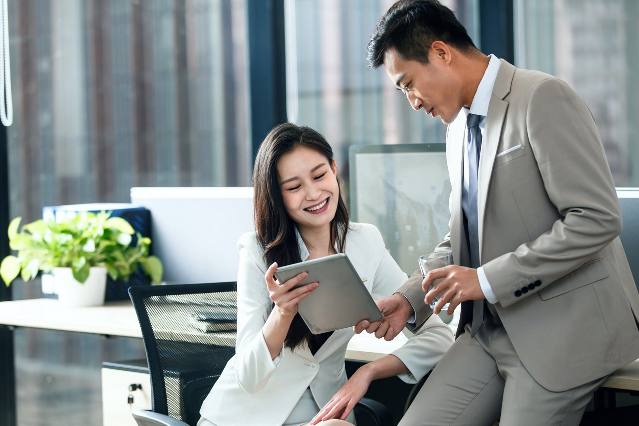 A woman safeguards her financial planning with wealth management solutions from an AIA partnered professional at a desk.