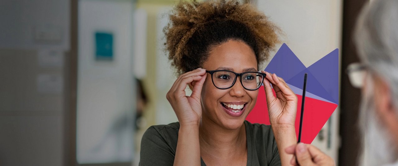 A woman with glasses examines her reflection in a mirror