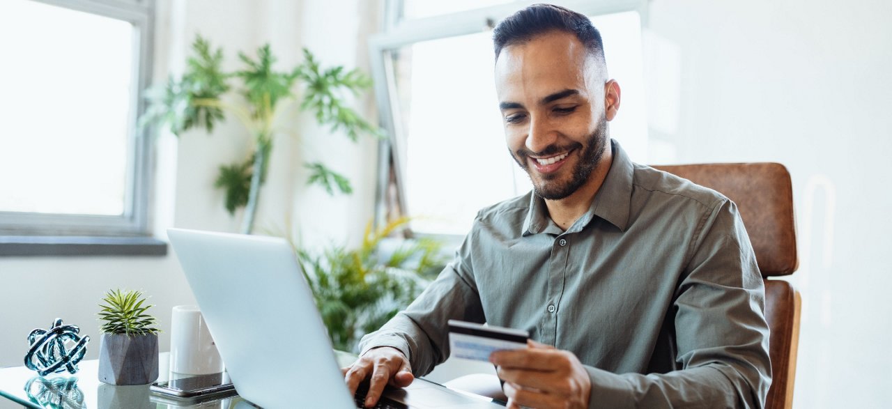 Middle aged man at laptop reading credit card numbers