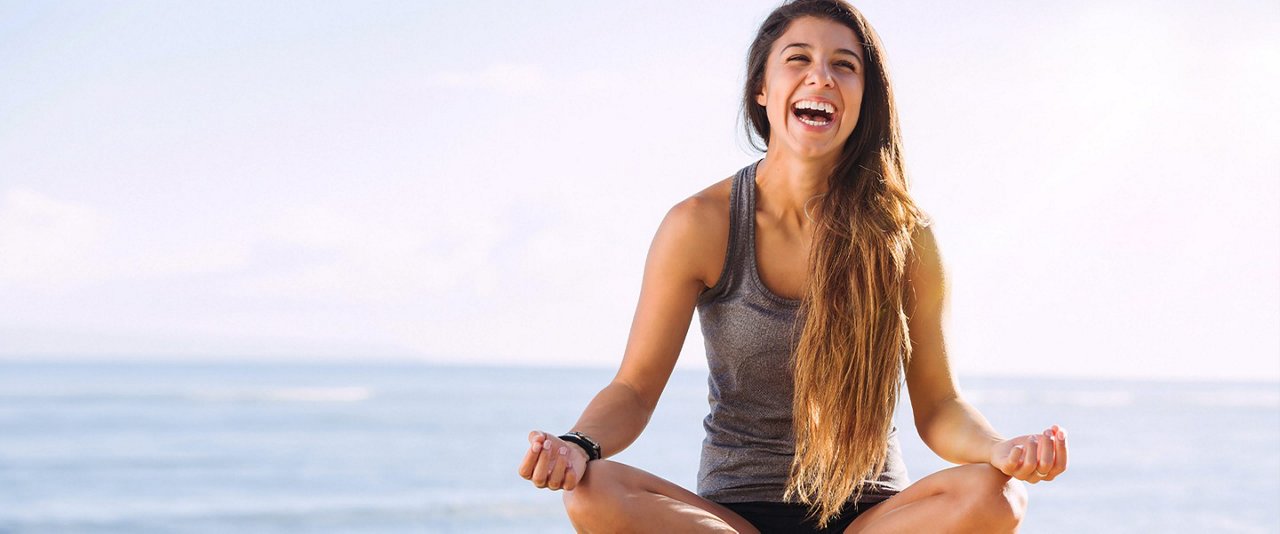 Lady on beach in a pose laughing