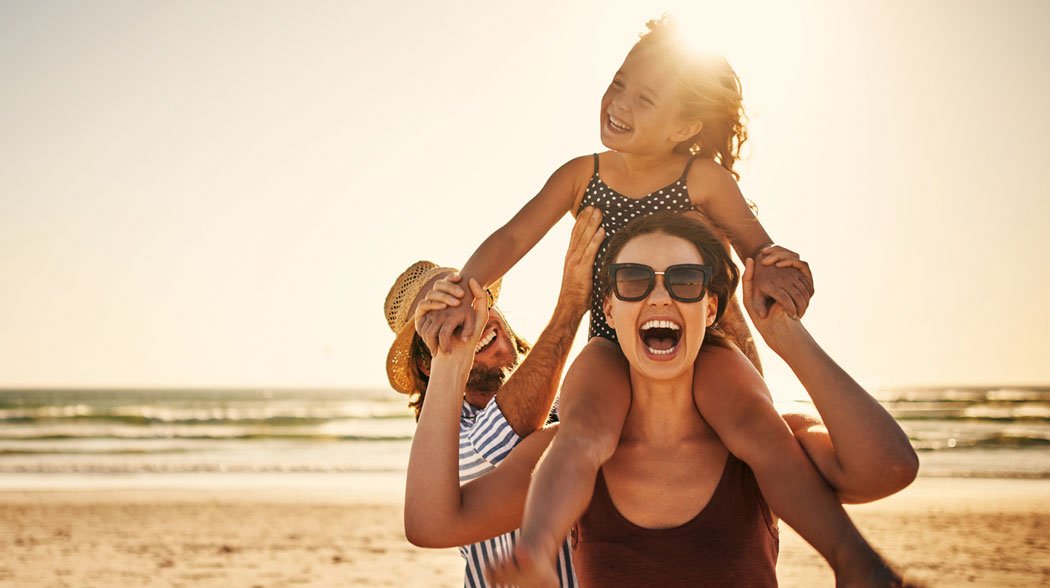 woman carrying daughter on her shoulder