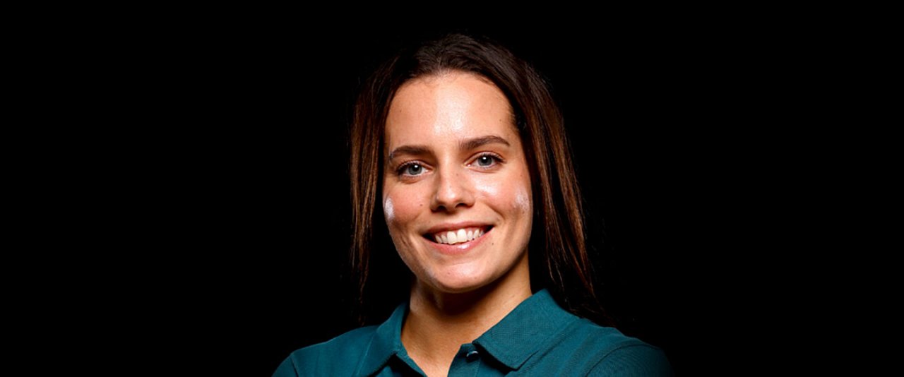 A woman smiling while wearing a blue shirt