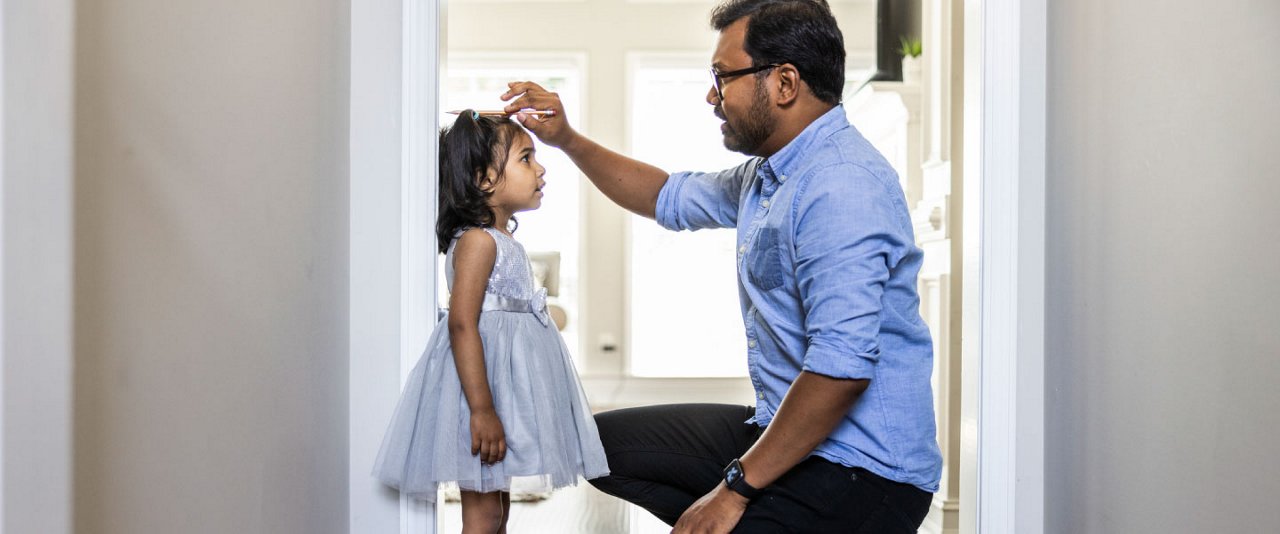 Dad measuring height of daughter