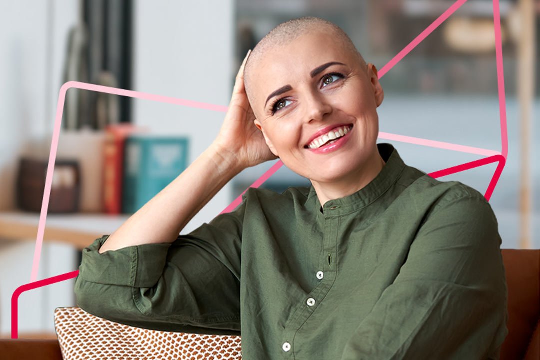 A woman with a shaved head lounges on a couch, appearing serene and at ease in her surroundings