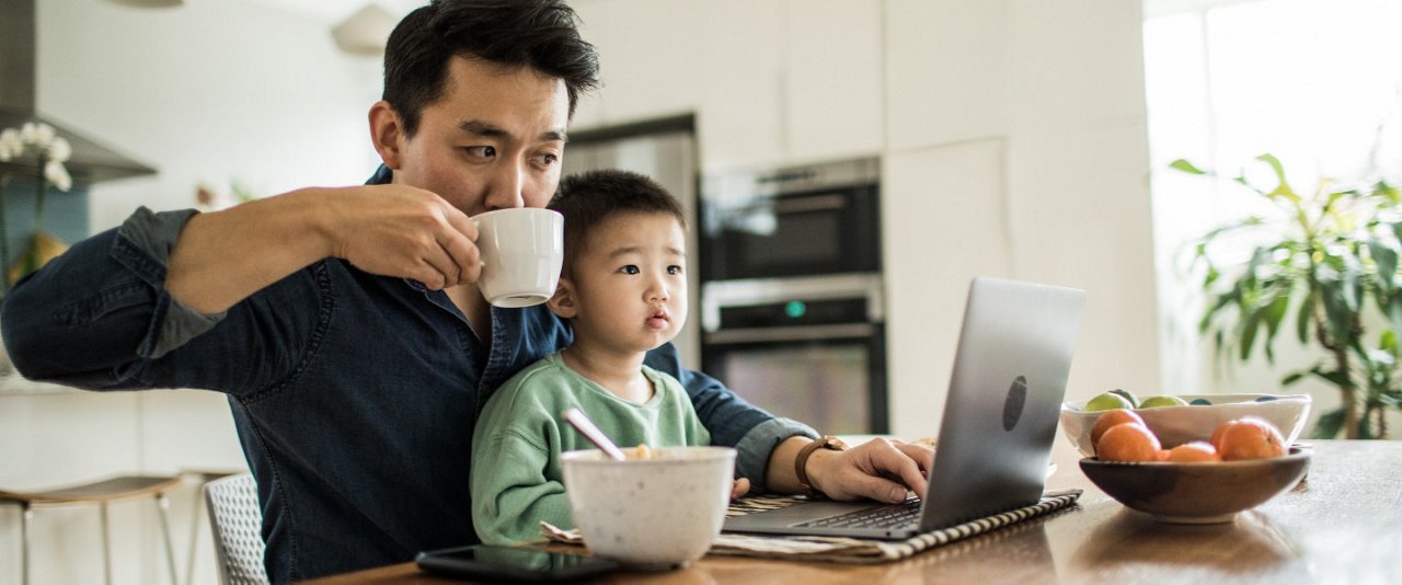Dad drinking from cup while son sits with him