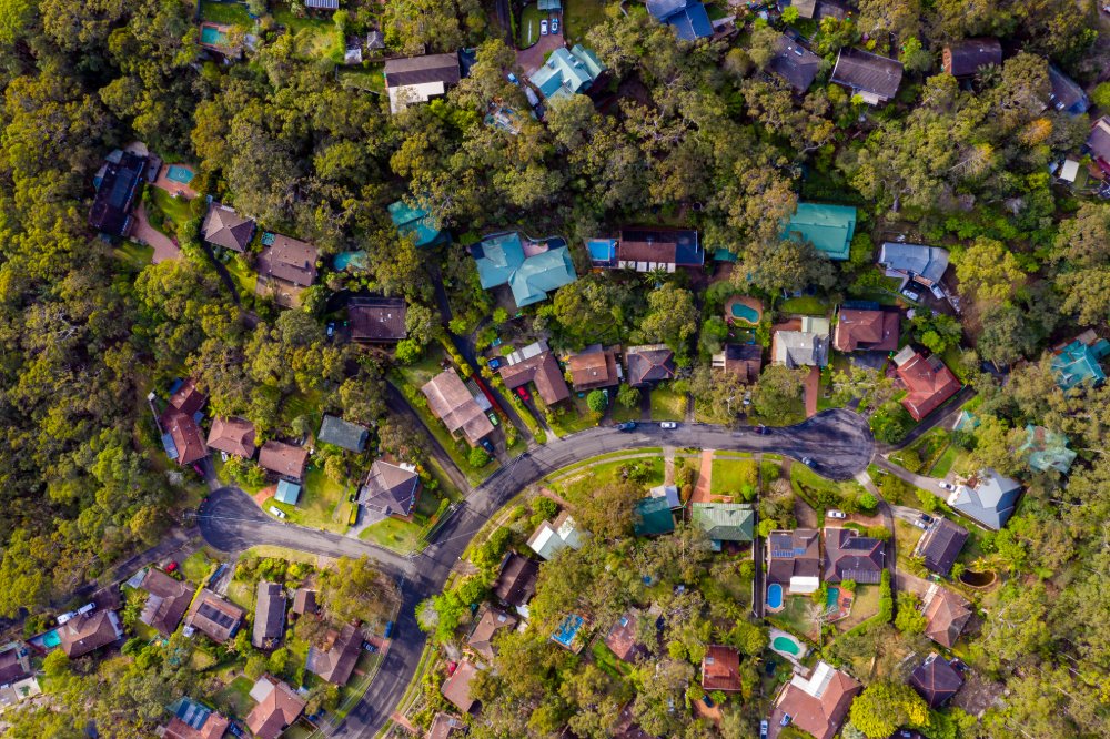 Aerial view showcasing a residential neighborhood in Sydney, Australia, featuring houses and greenery.