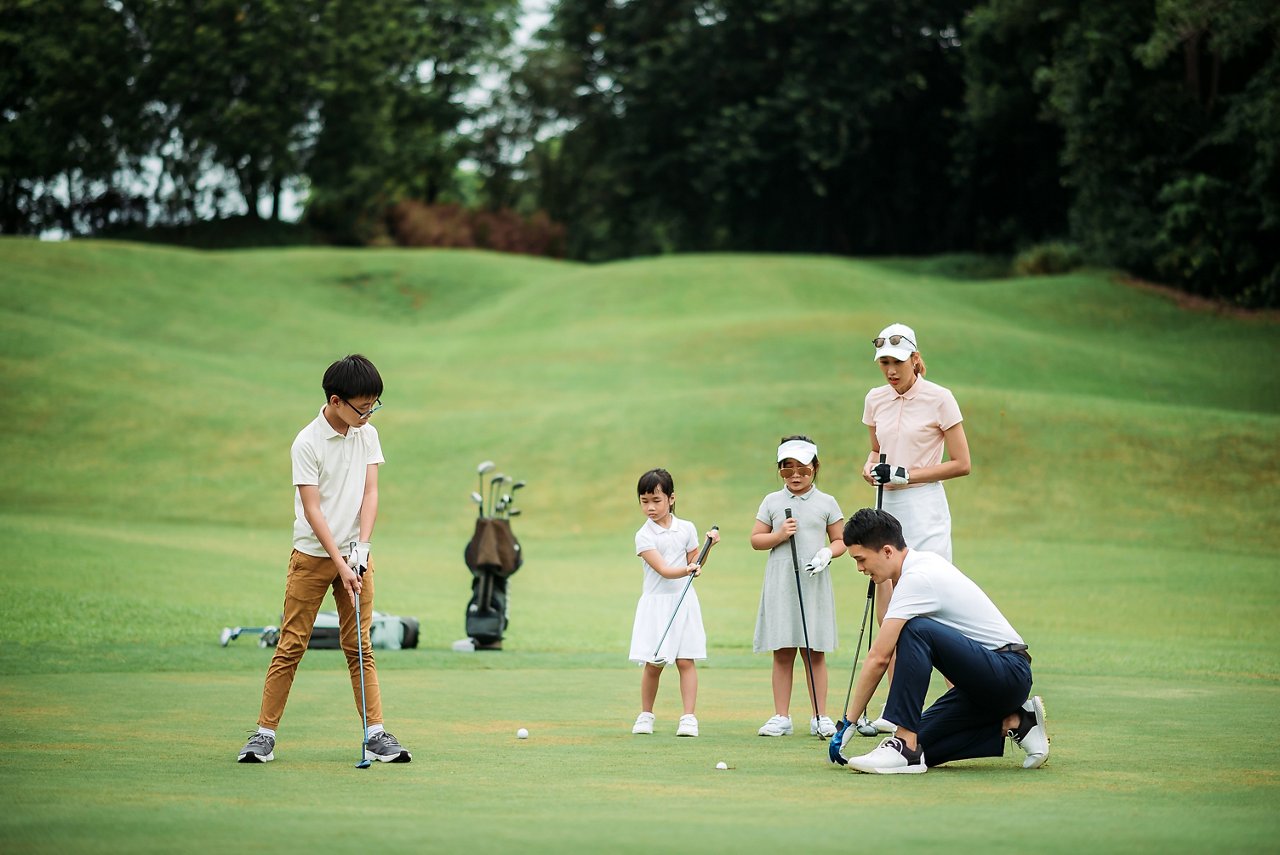一家人在高爾夫球場打高爾夫球