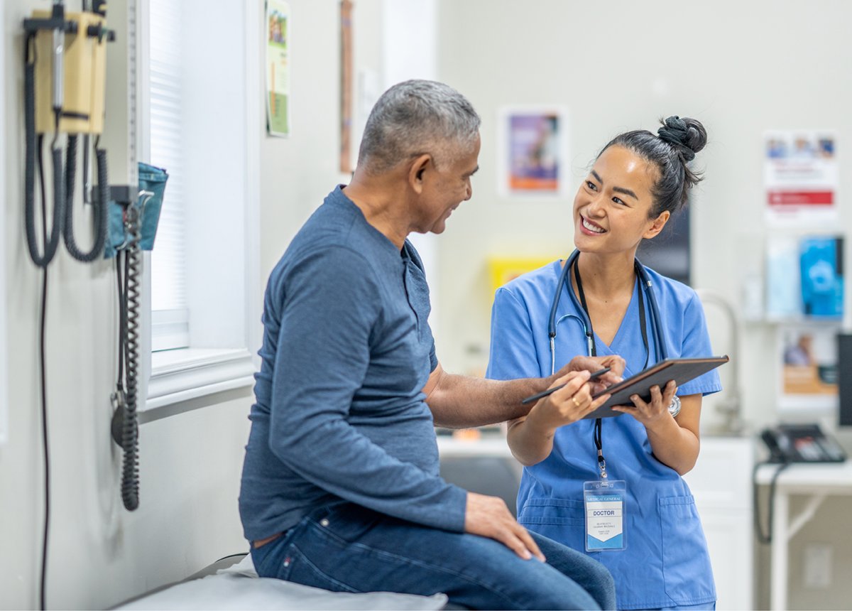 A nurse assists a patient in a hospital room