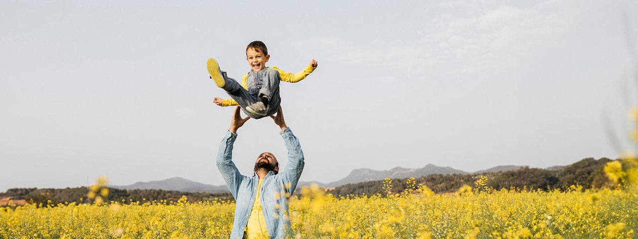 Father throwing his child in the air in happiness