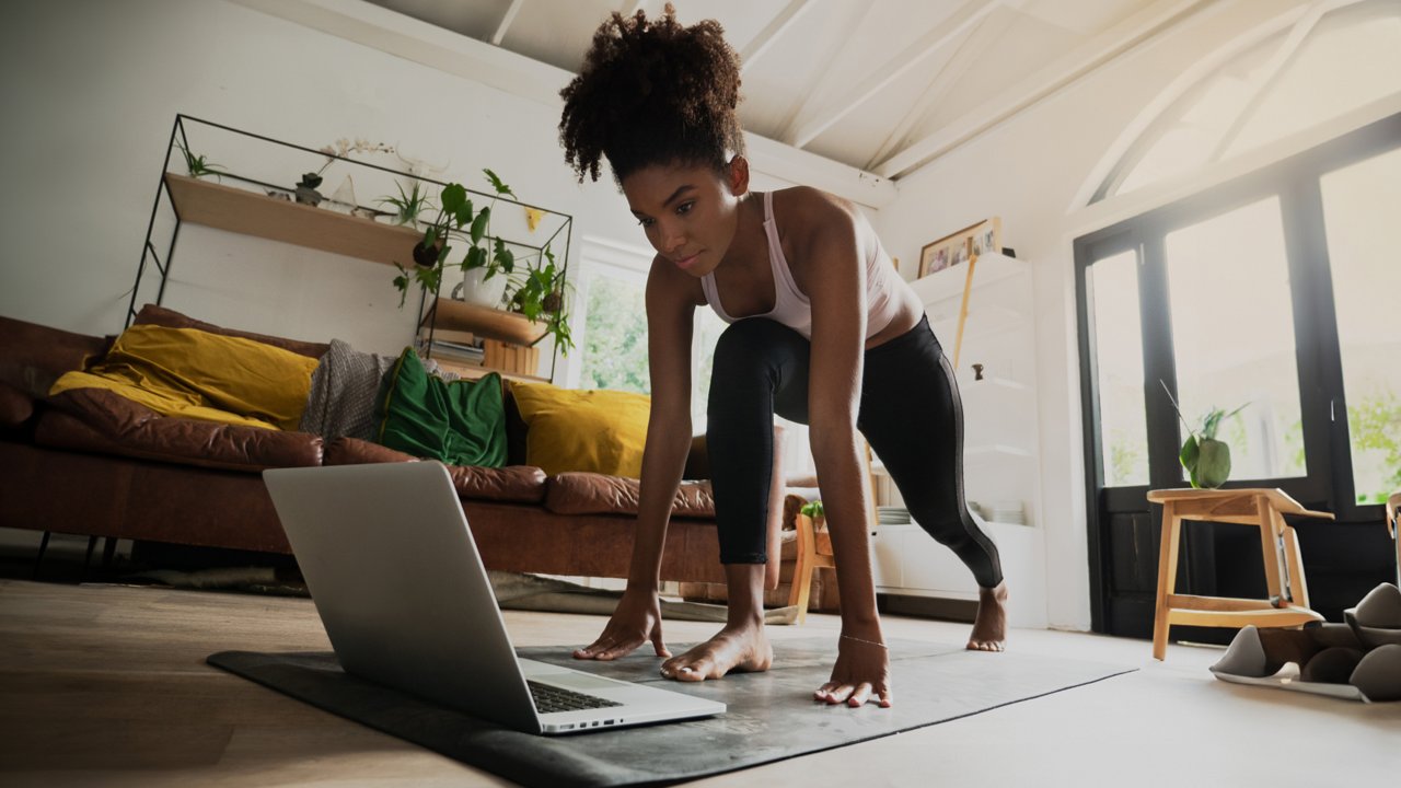 woman exercising watching video on laptop