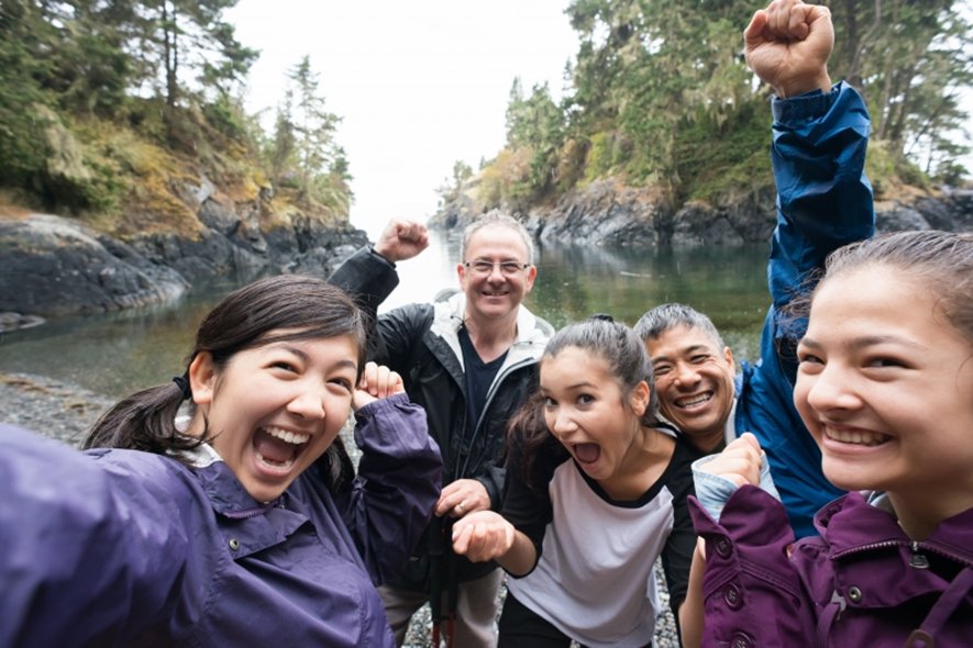 一群本地及外國朋友行山後，於湖面前開心地合照。運動和定期體育活動對您的免疫系統有巨大的正面影響。
