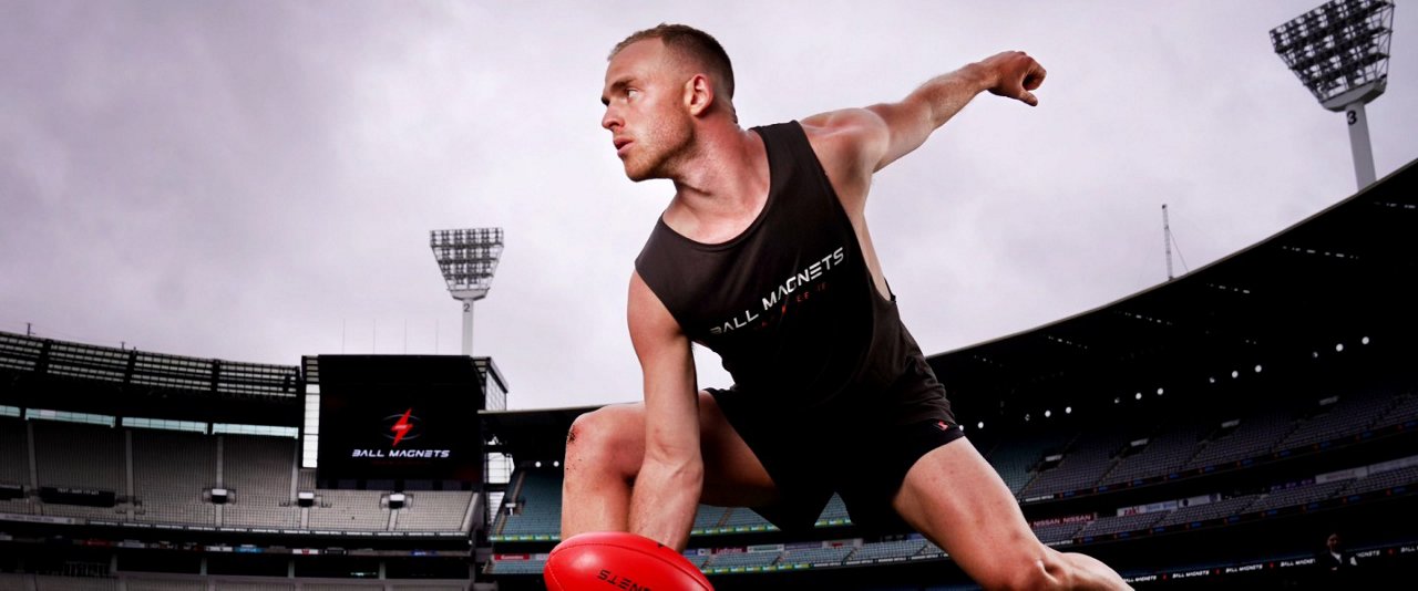 AFL player preparing to throw a ball.