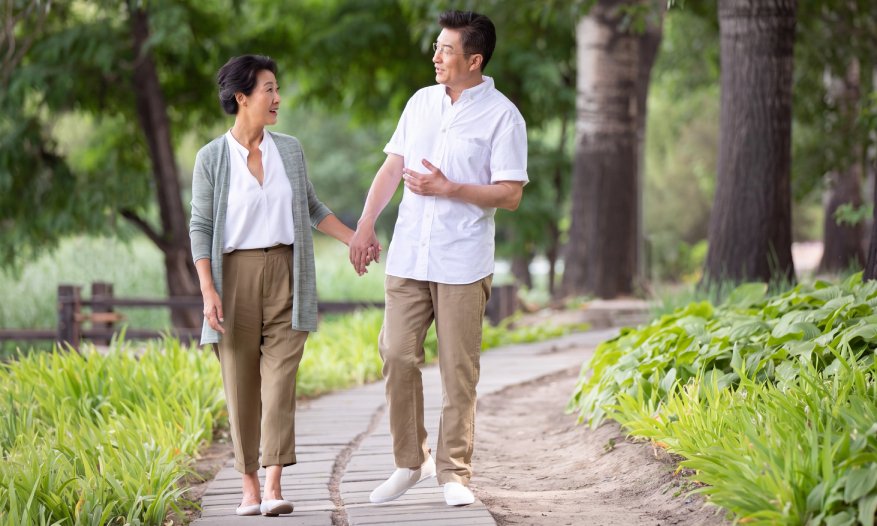 一對退休人士在公園散步，展現健康、積極及自主的退休生活。