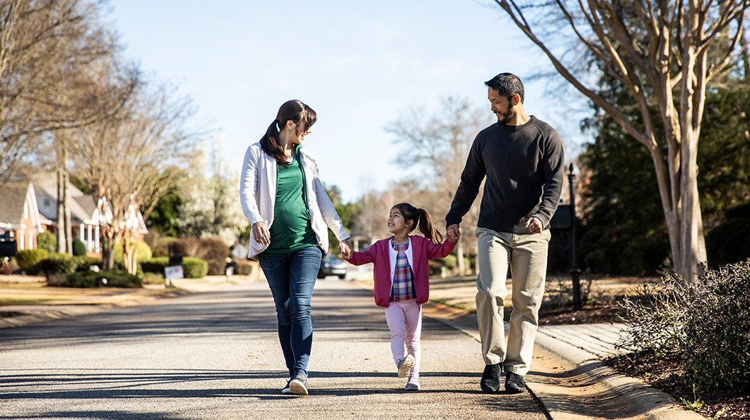 couple waking with daughter holding hands