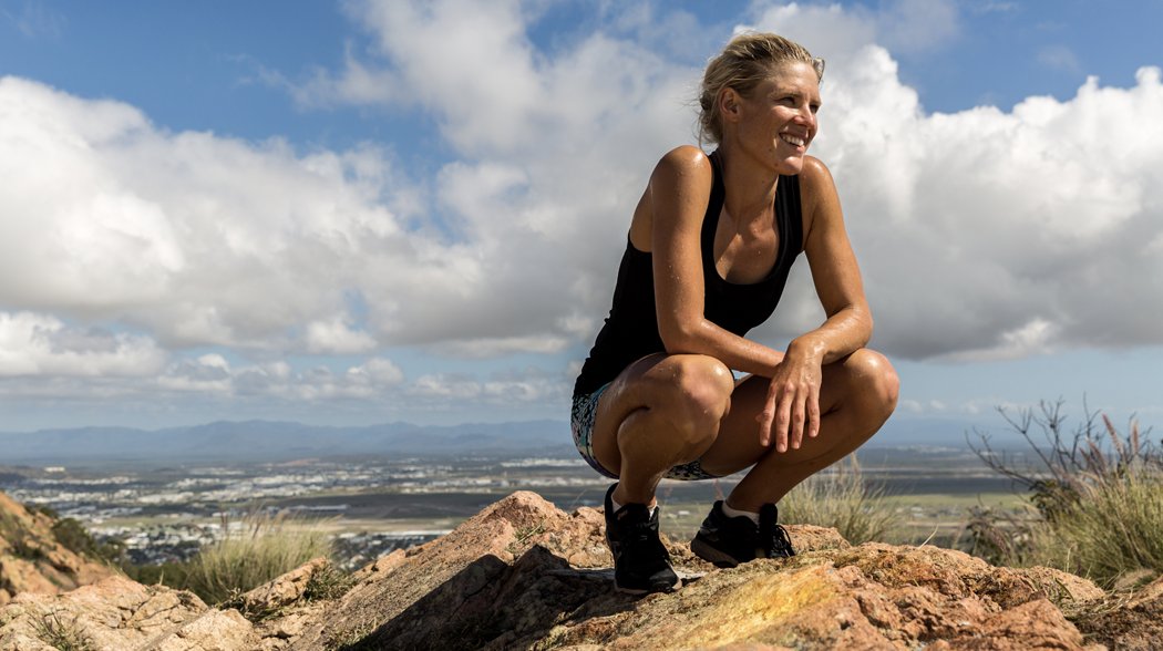 a woman sitting on a mountain top