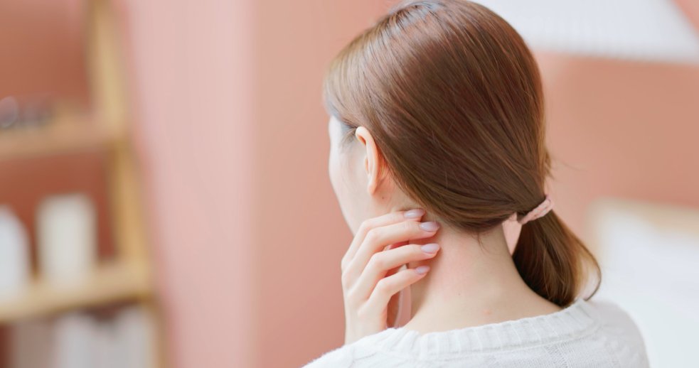 一名亞洲女性以手指觸摸下顎與頸側位置，自我檢查頸部淋巴結是否有腫大或壓痛。 