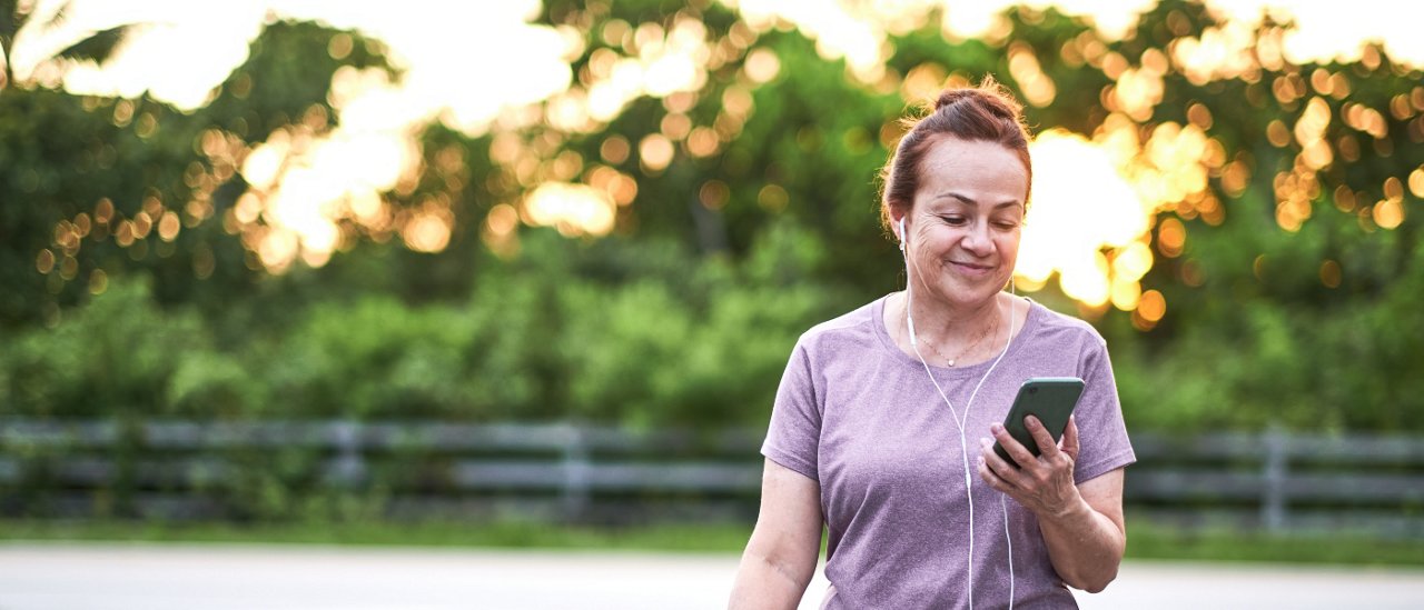 Middle aged woman running in a leafy park